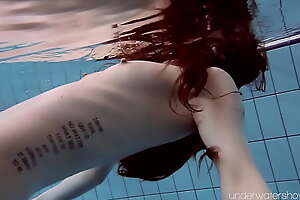 Roxalana Cheh floating naked alone approximately the pool